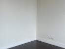 Empty living room with dark wooden floor and wall-mounted air conditioner