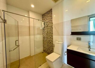 Modern bathroom with glass shower, toilet, and sink