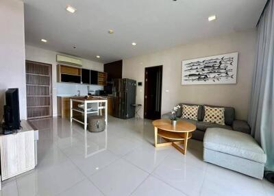 Spacious living room with modern decor and open kitchen.