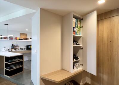 Open kitchen with built-in wooden cabinetry and floor shelf