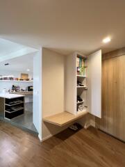 Open kitchen with built-in wooden cabinetry and floor shelf