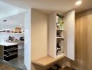 Open kitchen with built-in wooden cabinetry and floor shelf