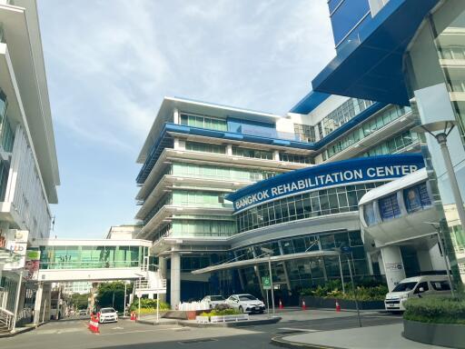 Front view of Bangkok Rehabilitation Center with modern architecture and clear sky