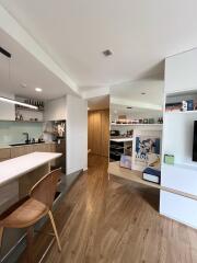 Modern kitchen and living area with wooden flooring and built-in shelves