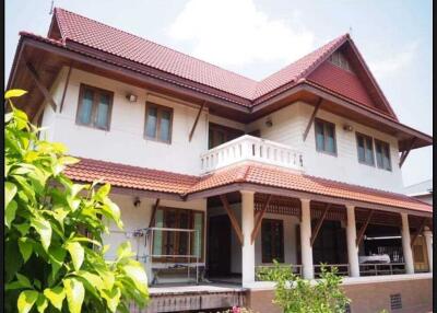 Exterior of a two-story house with red roof and veranda