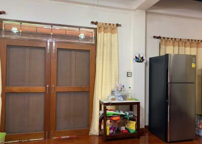 Kitchen with double wooden doors and refrigerator