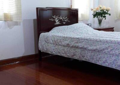 A cozy bedroom with wooden flooring and windows