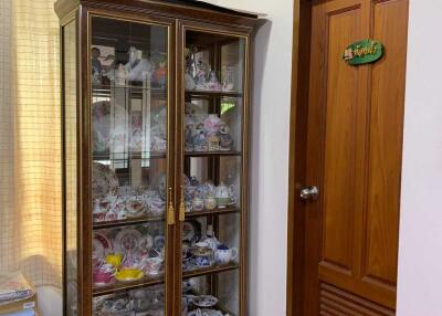 Display cabinet with decorative items next to a wooden door