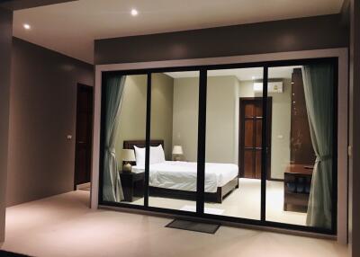 Bedroom with sliding glass doors and modern lighting