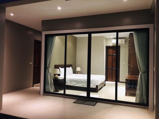 Bedroom with sliding glass doors and modern lighting