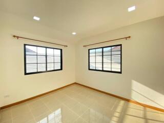 Bright bedroom with tiled flooor and large windows.