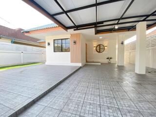 Modern carport structure with partial view of house