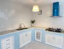 Modern kitchen with blue and white cabinets and gas stove