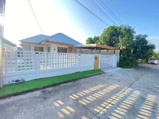 Exterior view of a house with white fence and green yard