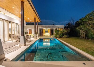 Luxury outdoor pool area with seating and nighttime view