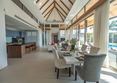 Modern open-plan dining and living area with kitchen and pool view
