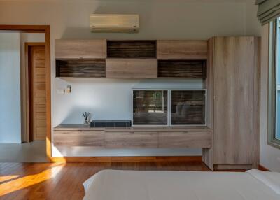 Modern bedroom with wooden furnishings and wall-mounted cabinetry