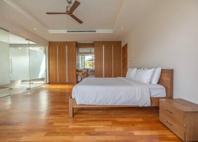 Spacious and modern bedroom with wooden floors and furniture