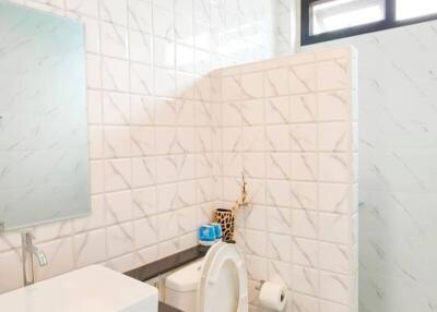 Bright modern bathroom with white tiled walls and vanity mirror