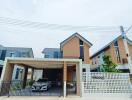 Modern two-story house with a garage and landscaped garden.