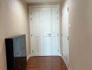 Clean hallway with wooden floors and white doors