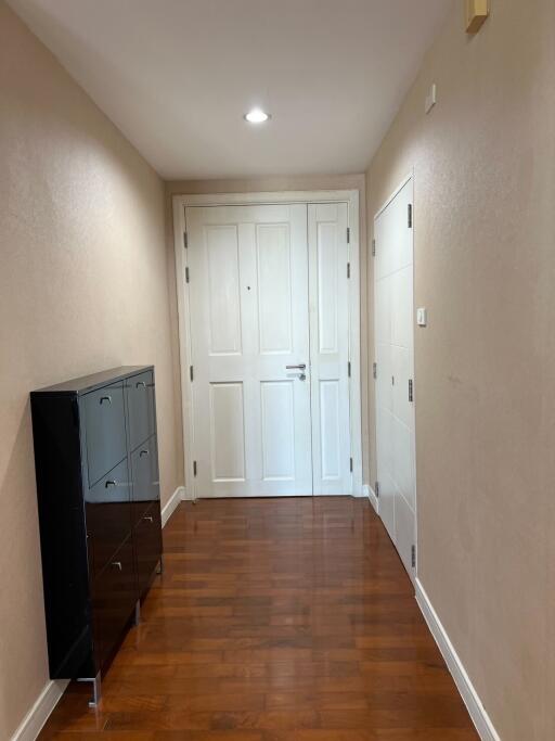 Clean hallway with wooden floors and white doors