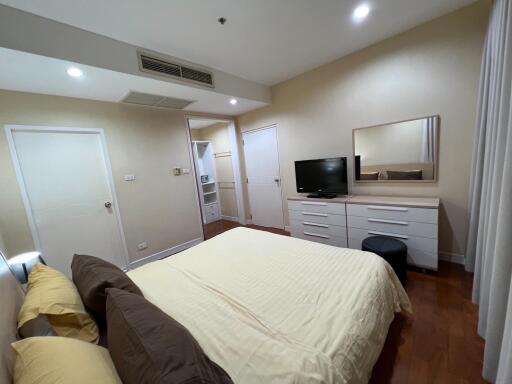 Master bedroom with TV, dresser, and comfortable lighting