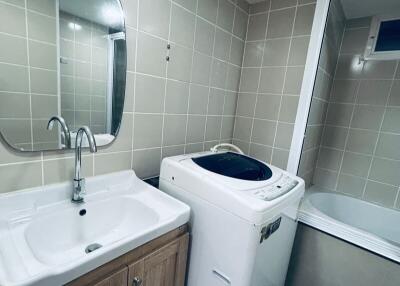 Bathroom with washing machine and bathtub