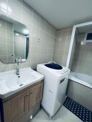 Bathroom with washing machine and bathtub