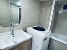 Bathroom with washing machine and bathtub