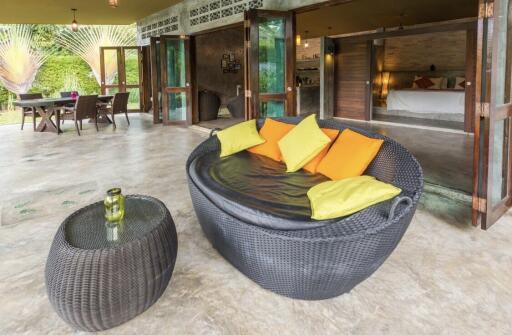 Outdoor patio with seating area and view into bedroom