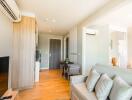 Bright and modern living room with wooden flooring and grey furniture.