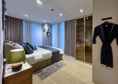 modern bedroom with large windows, bed, nightstand, and wardrobe