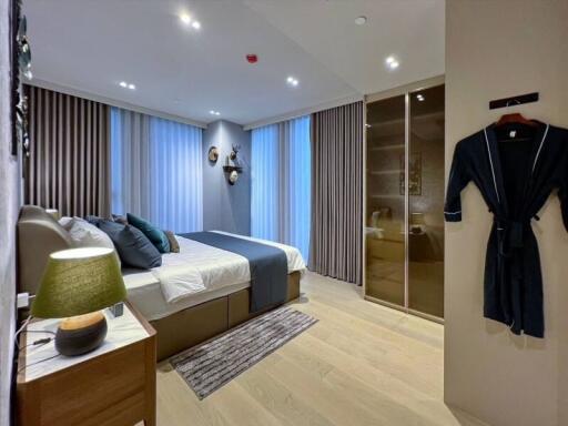 modern bedroom with large windows, bed, nightstand, and wardrobe