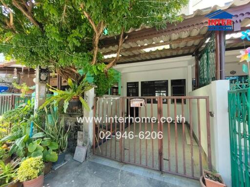 Front view of a house with a gated entrance and garden