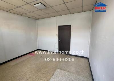 Empty room with tiled floor and a wooden door
