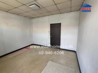 Empty room with tiled floor and a wooden door