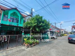 Street view of residential buildings with cars parked