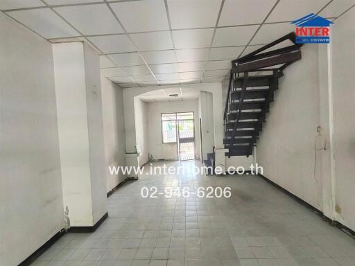 Spacious main living area with tile flooring and natural light.