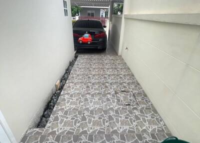 Covered garage with tiled flooring and parked car