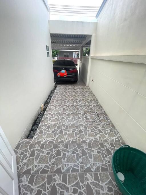 Covered garage with tiled flooring and parked car