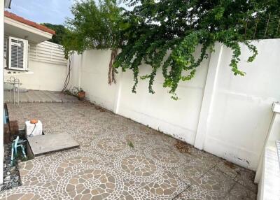 Outdoor patio with tiled flooring and greenery
