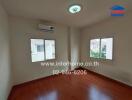 Empty bedroom with wooden flooring and air conditioner