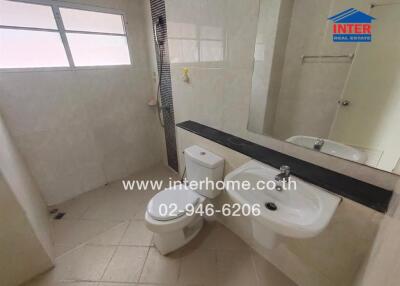 Bathroom with toilet, sink, large mirror and window