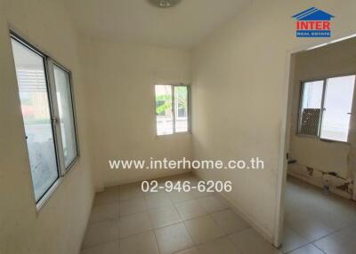 Small unfurnished room with tiled floor and windows