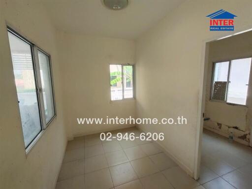 Small unfurnished room with tiled floor and windows