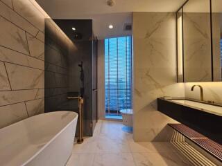 Luxurious modern bathroom with freestanding bathtub, walk-in shower, and dual sinks