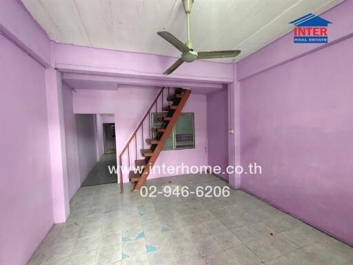 Living room with purple walls and a staircase
