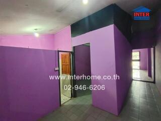Purple-painted apartment corridor with multiple rooms and a visible wooden door