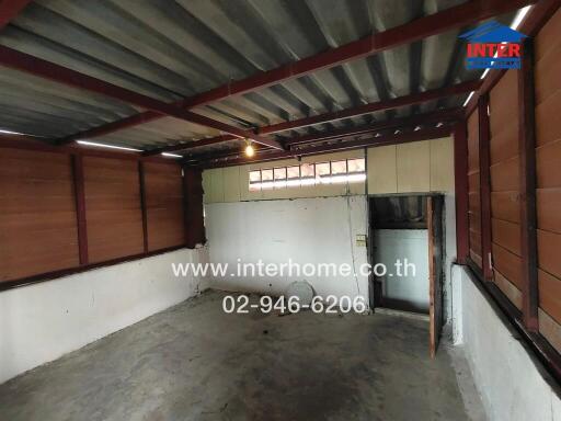 Empty unfinished room with concrete floor and wooden walls